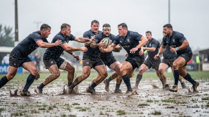 rugby_sous_la_pluie_terrain_lourd-rjrgd1-2ihuw2 Une équipe masculine de rugby réalise une action de passe sur un terrain boueux et détrempé sous une forte pluie.