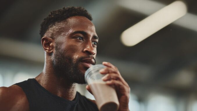 Sportif buvant une boisson de récupération après son entraînement